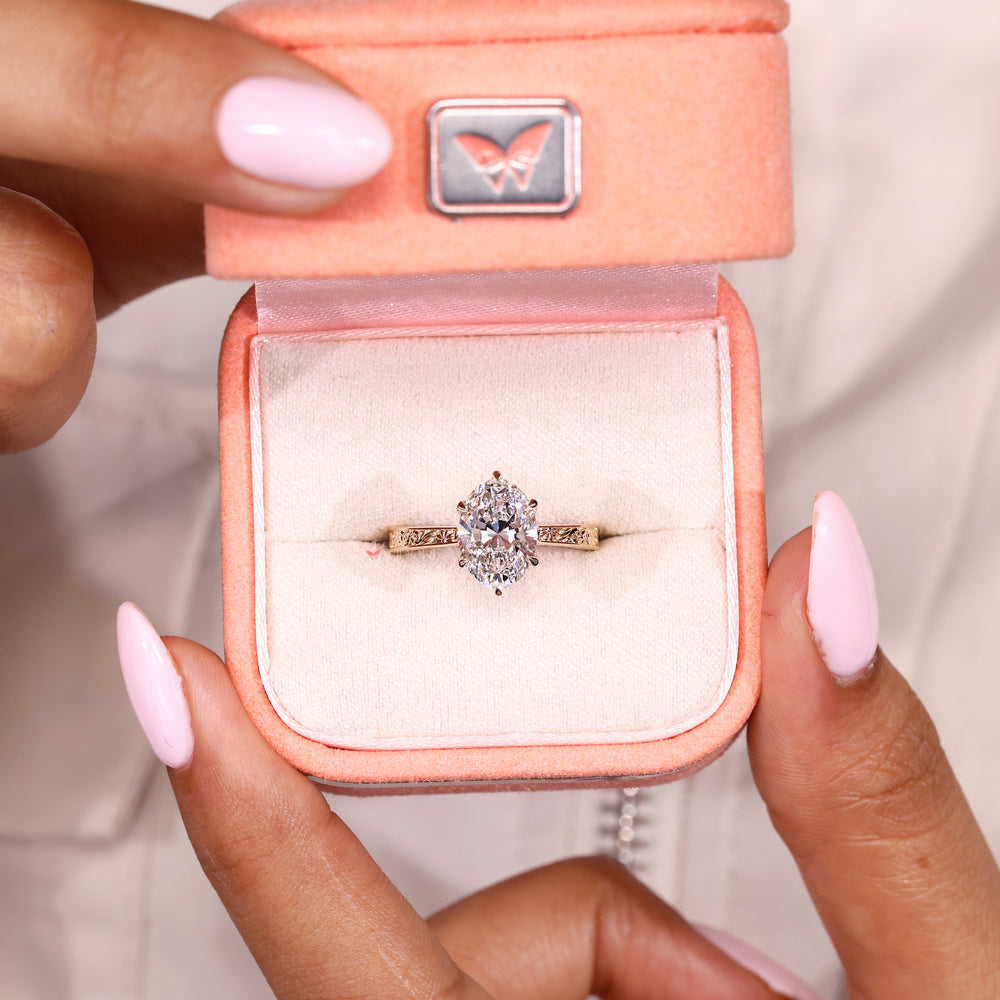 Oval engagement ring with tulip setting and ruby details
