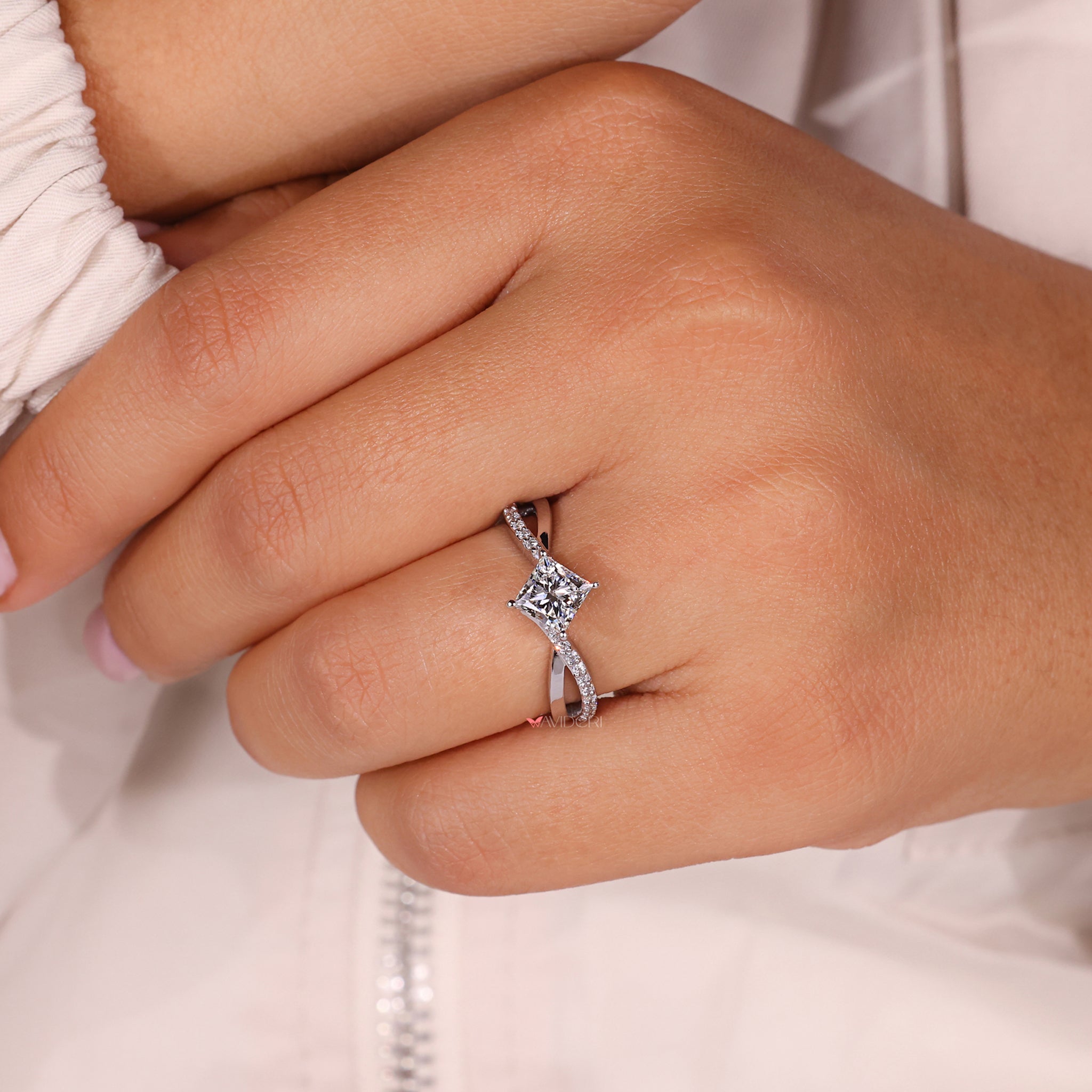 Claw prong setting with a princess cut diamond ring in an elegant twisted band style.
