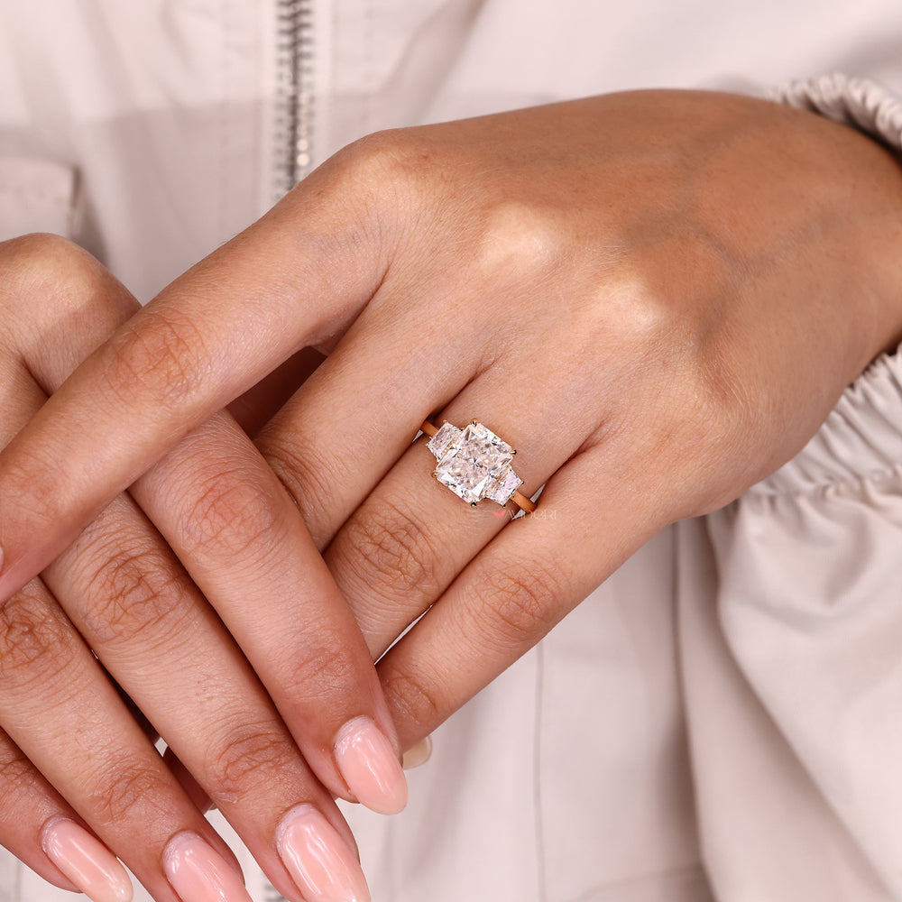 Radiant cut moissanite ring with geometric side stones.
