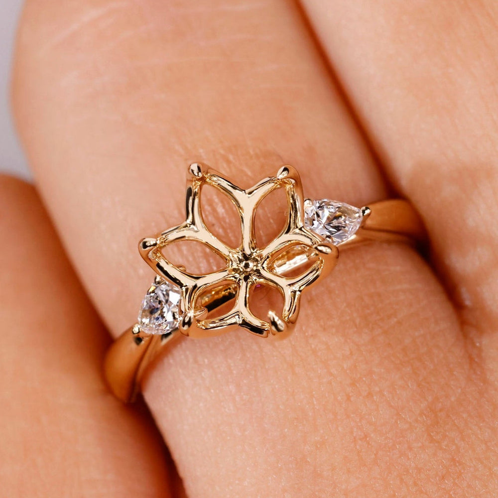 Custom diamond semi mount with pear side stones and cathedral setting in yellow gold.
