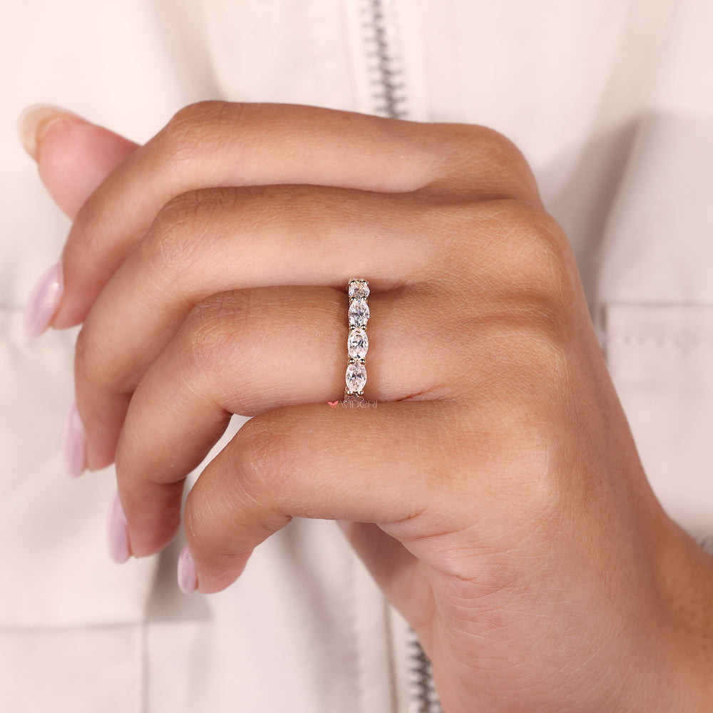 Yellow gold wedding band designed as a half eternity moissanite ring.
