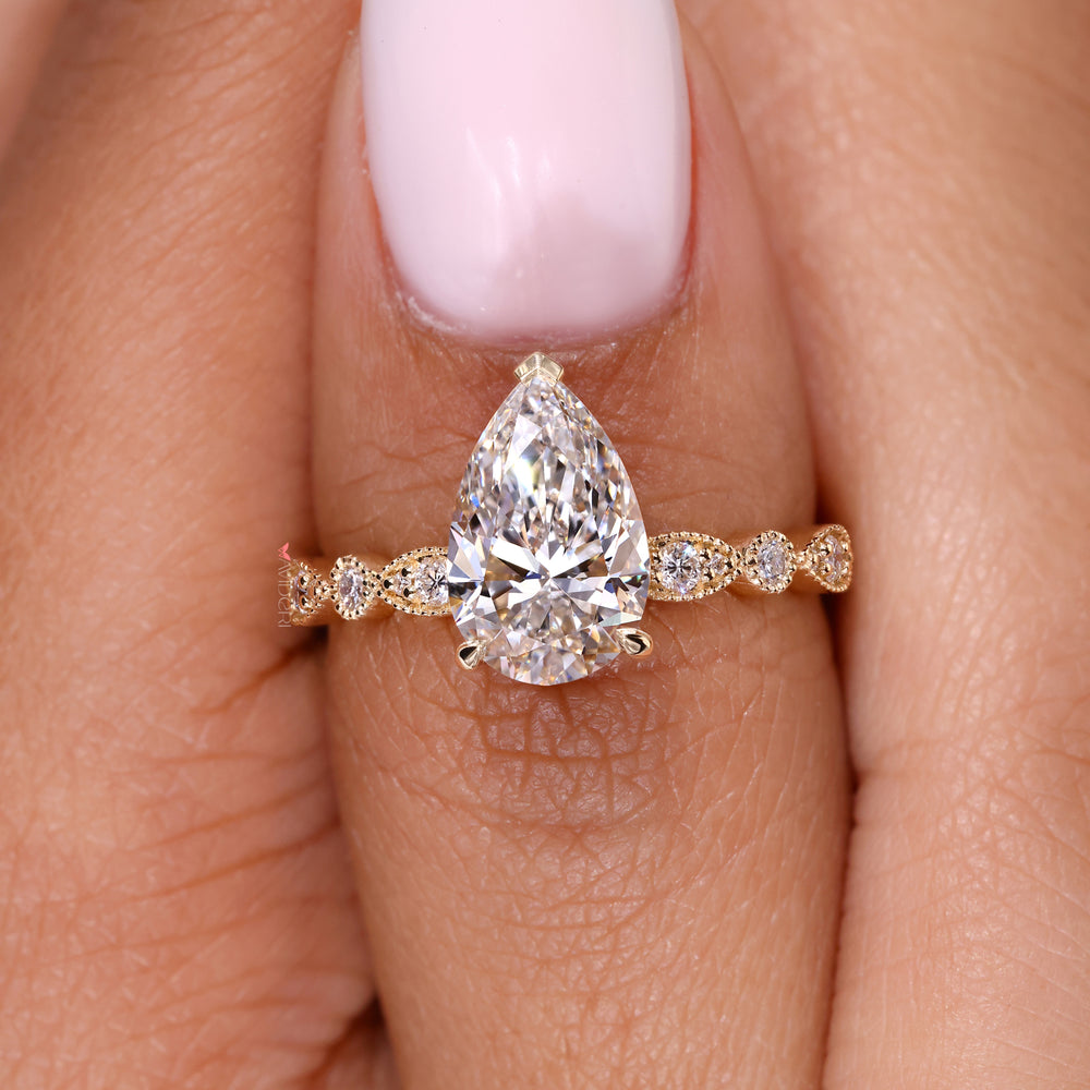 V prong ring setting holding a sparkling pear shaped diamond with secure elegance.
