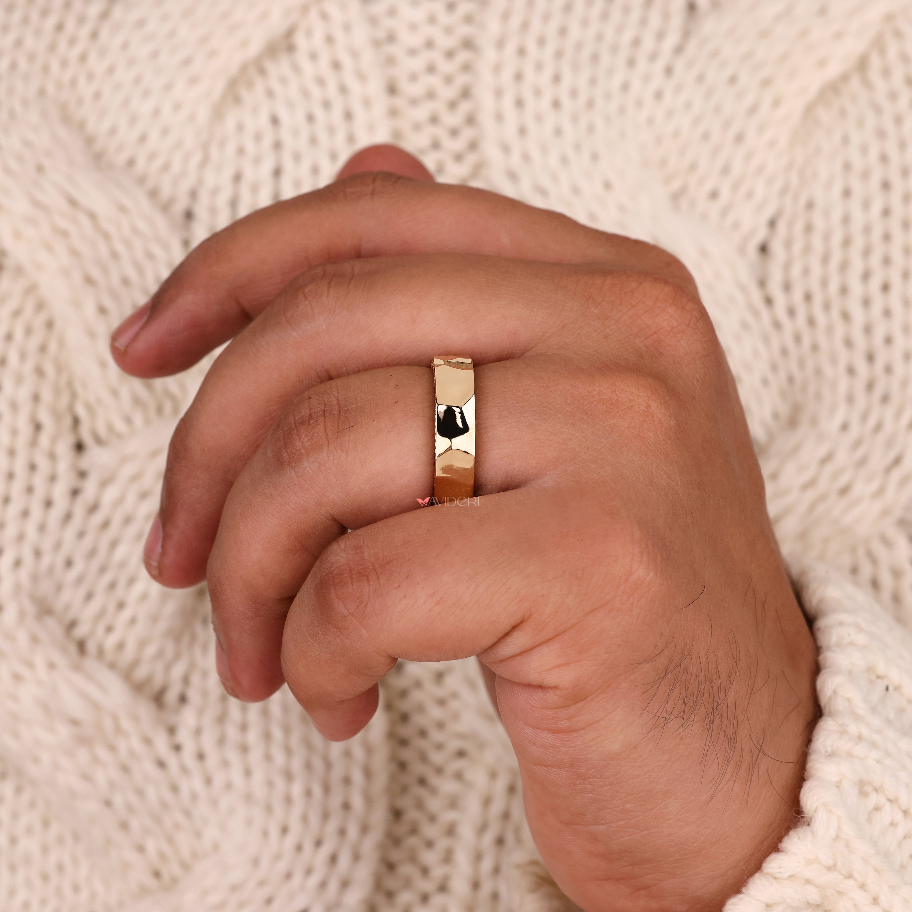 Handmade hammered wedding band with round cut diamond accents.
