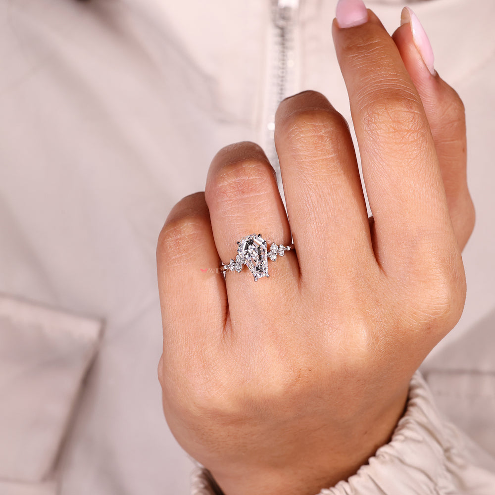Coffin cut diamond ring with round side stone detail.