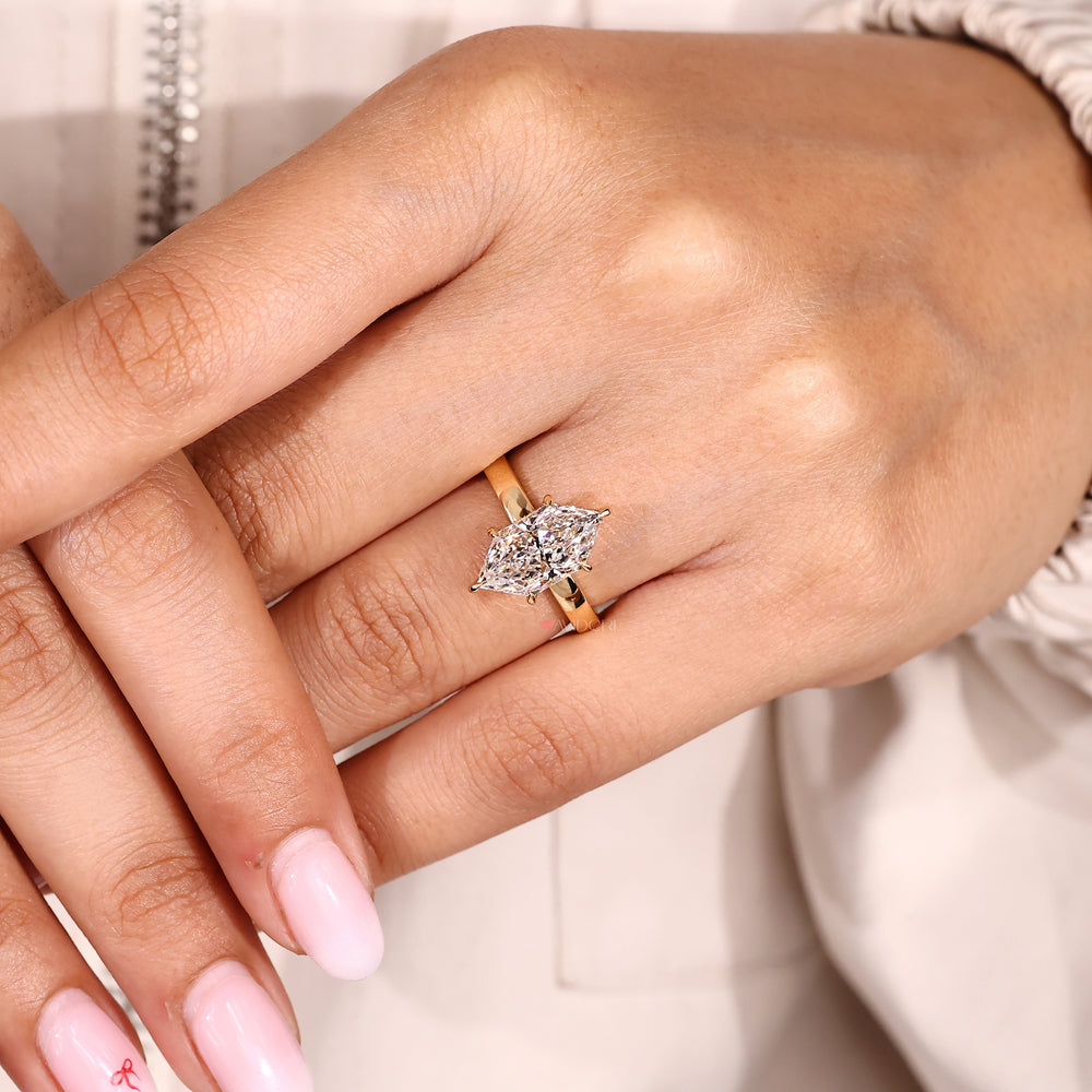 Round diamond hidden halo marquise ring design.