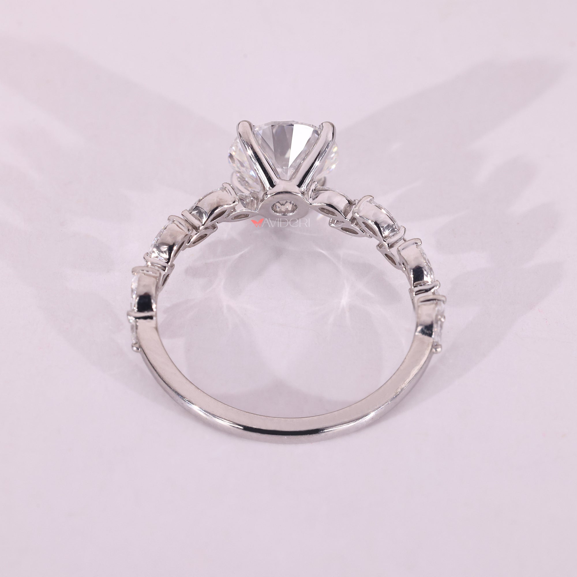 White gold engagement ring with a round diamond center, set in a four prong setting.