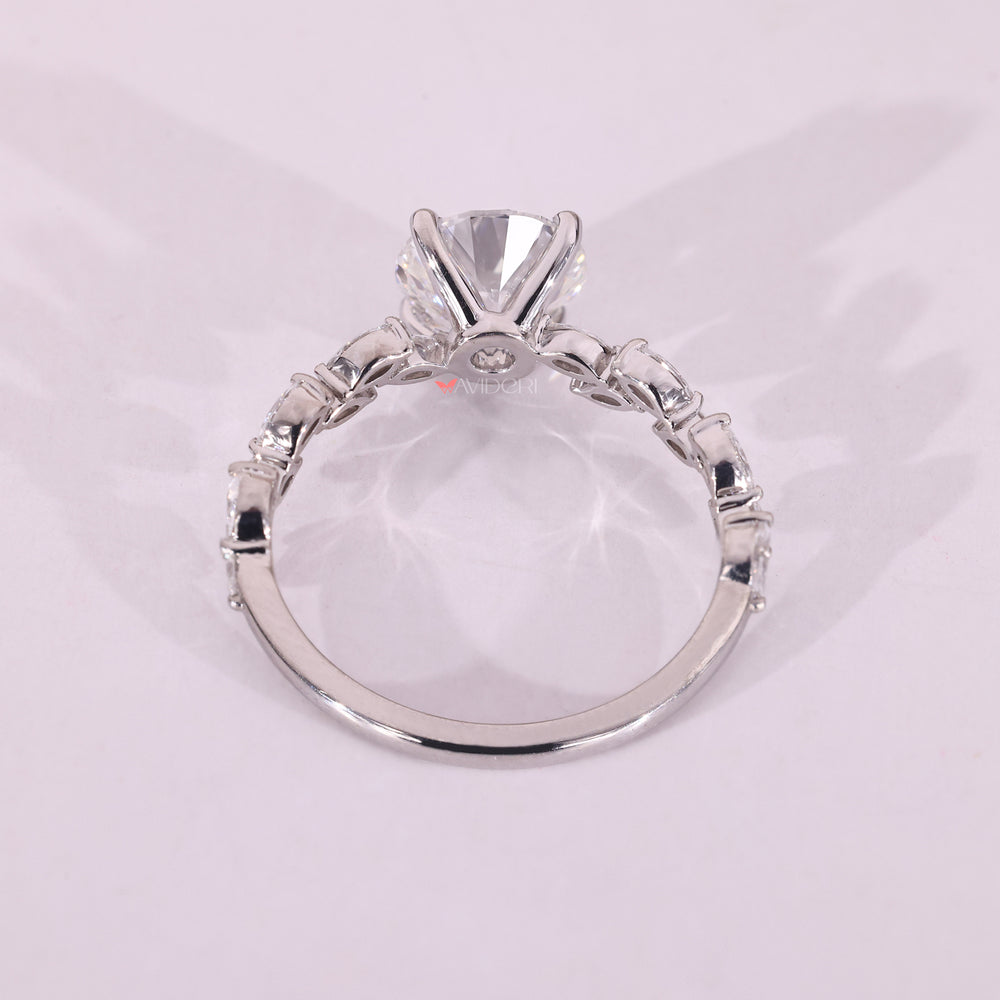 White gold engagement ring with a round diamond center, set in a four prong setting.