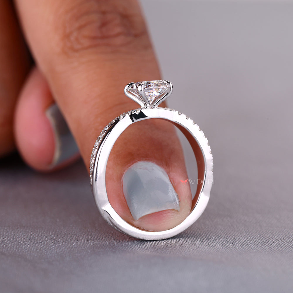Oval cut diamond engagement ring with claw prongs and a twisted band for a classic yet unique design.
