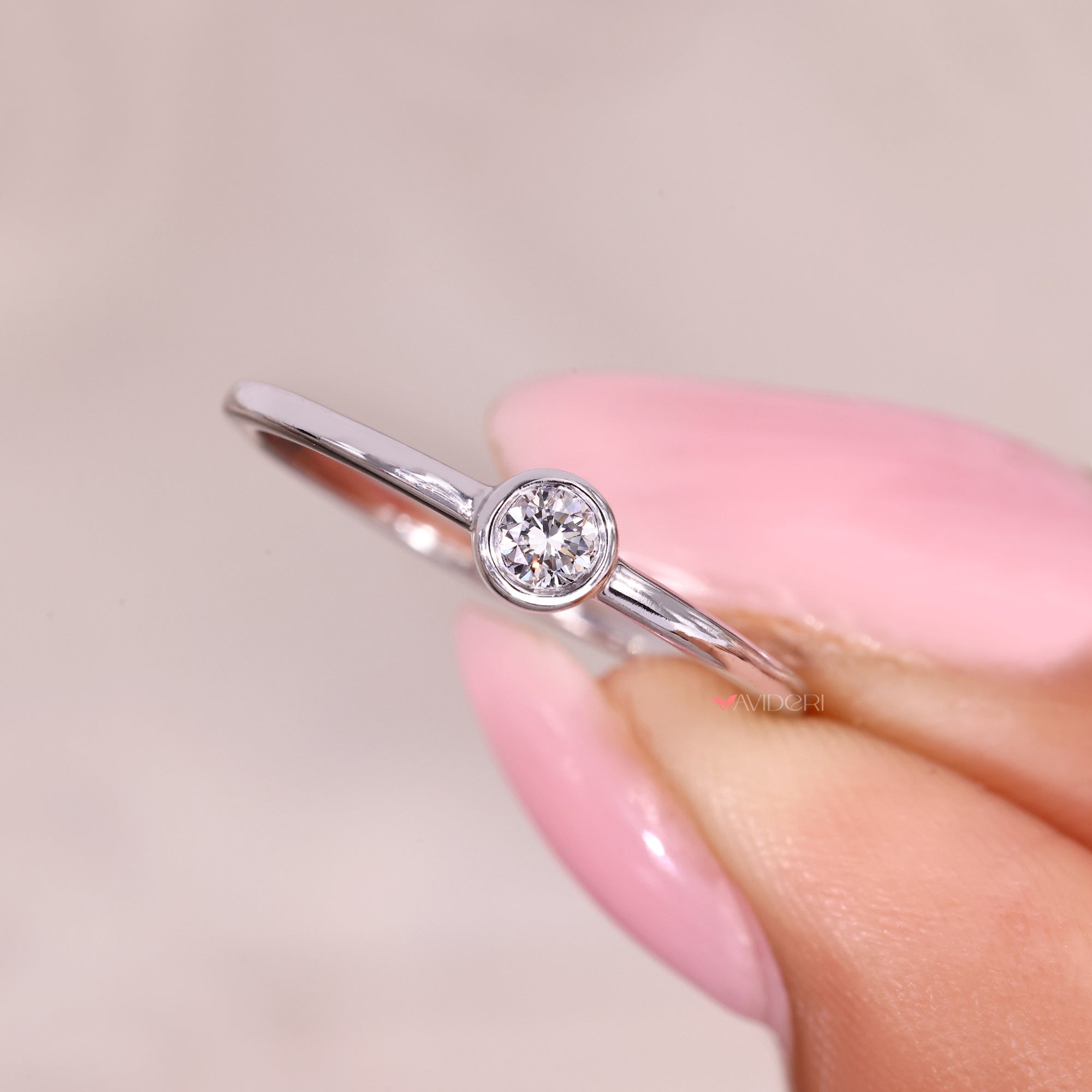 Bezel set round diamond ring with elegant profile.
