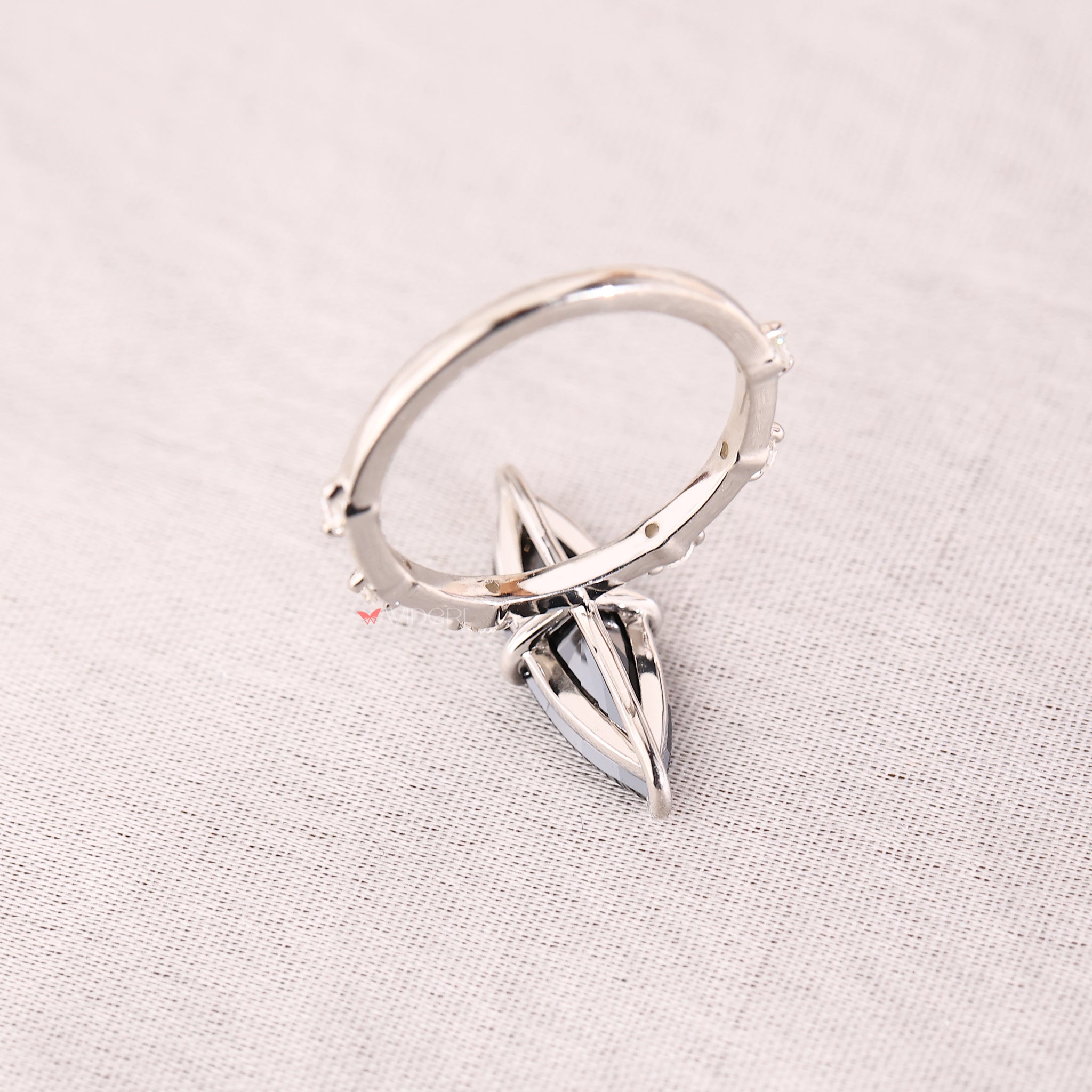 White gold ring with seven stones arranged in a compass prong style.