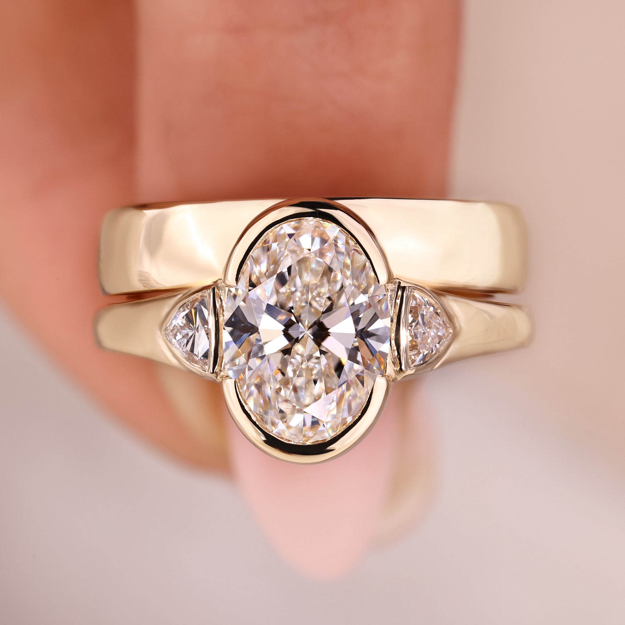 Oval diamond engagement ring paired with trillion side stones.