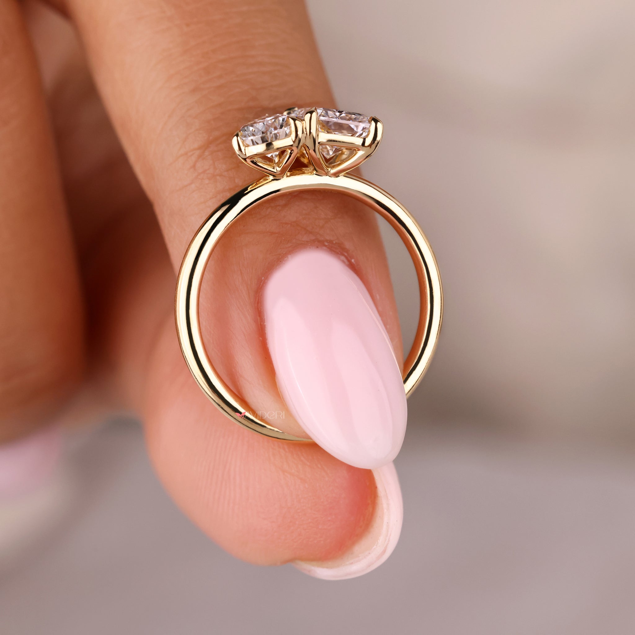 Yellow gold engagement ring featuring a radiant cut stone in a toi et moi design.
