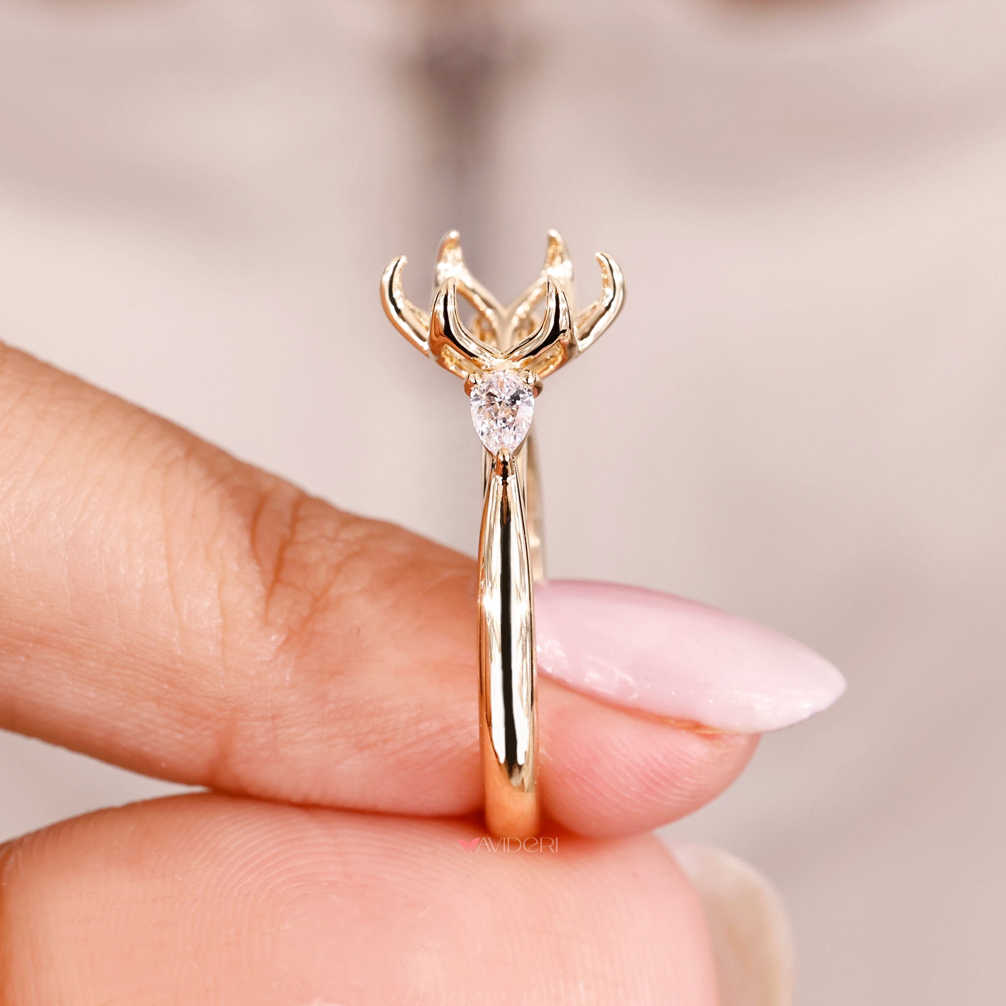 Avideri ring featuring pear side stones and cathedral mounting style.
