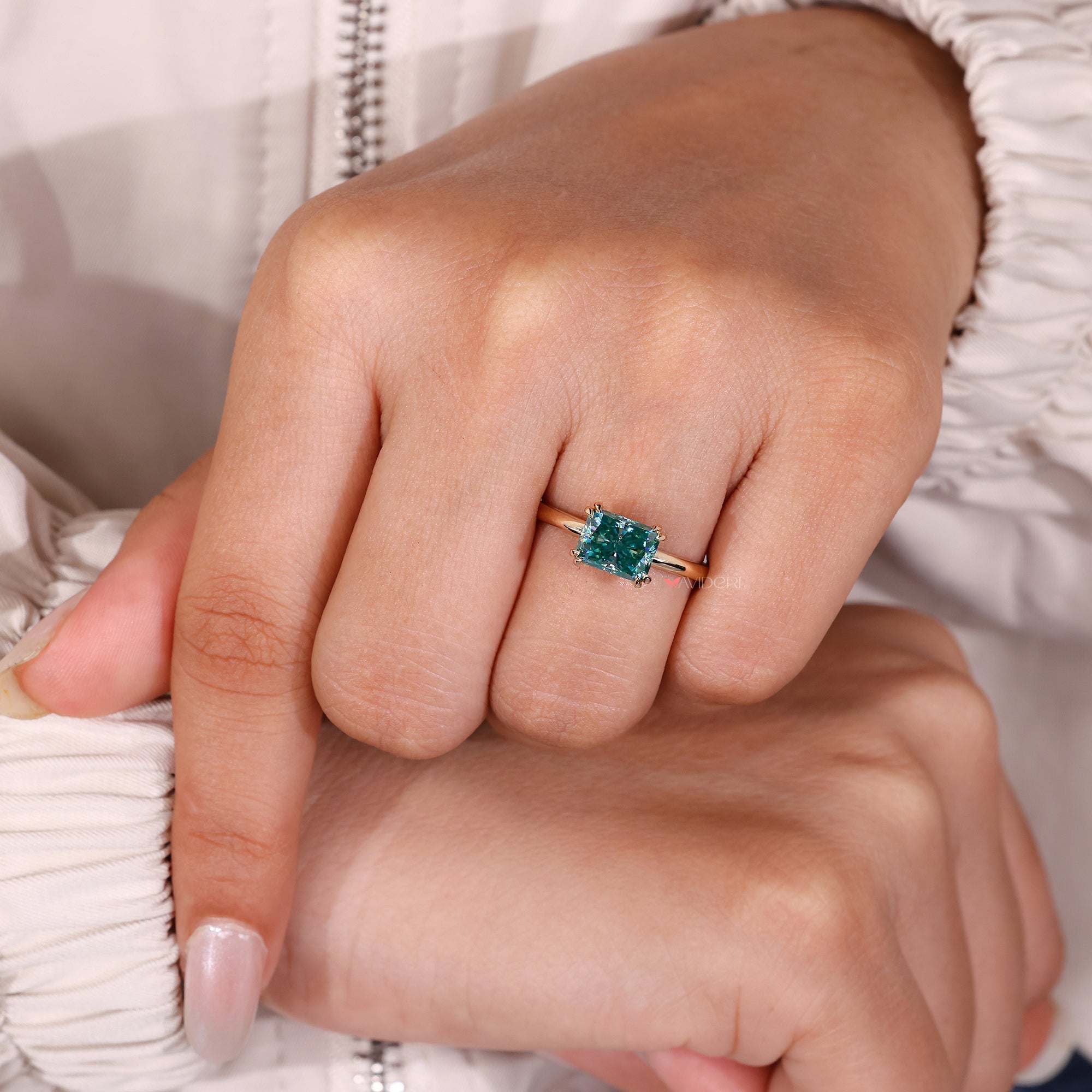 Cyan blue moissanite ring with east west setting.