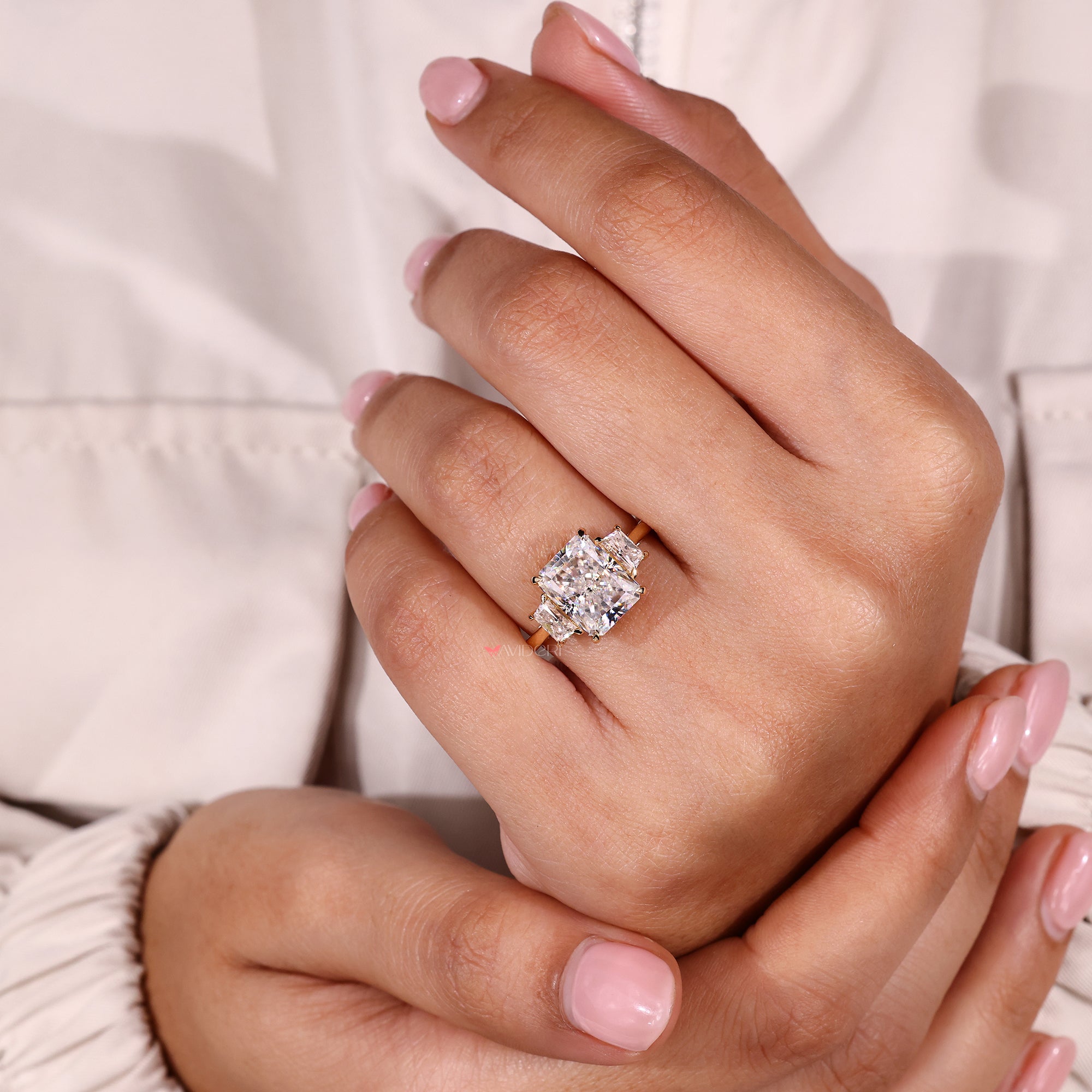 Trapezoid cut side moissanite set in yellow gold ring.