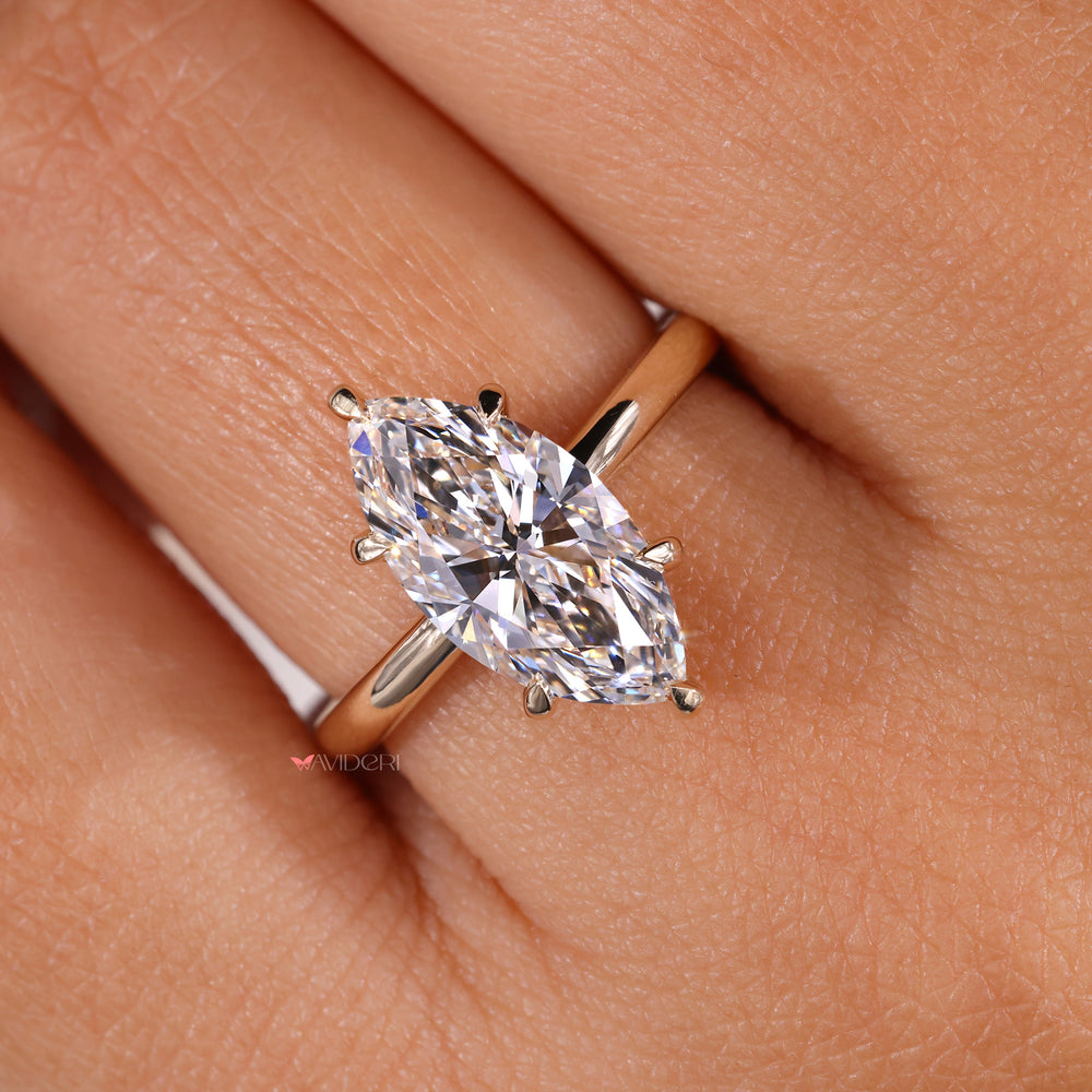 Gold solitaire engagement ring showcasing a Marquise diamond.
