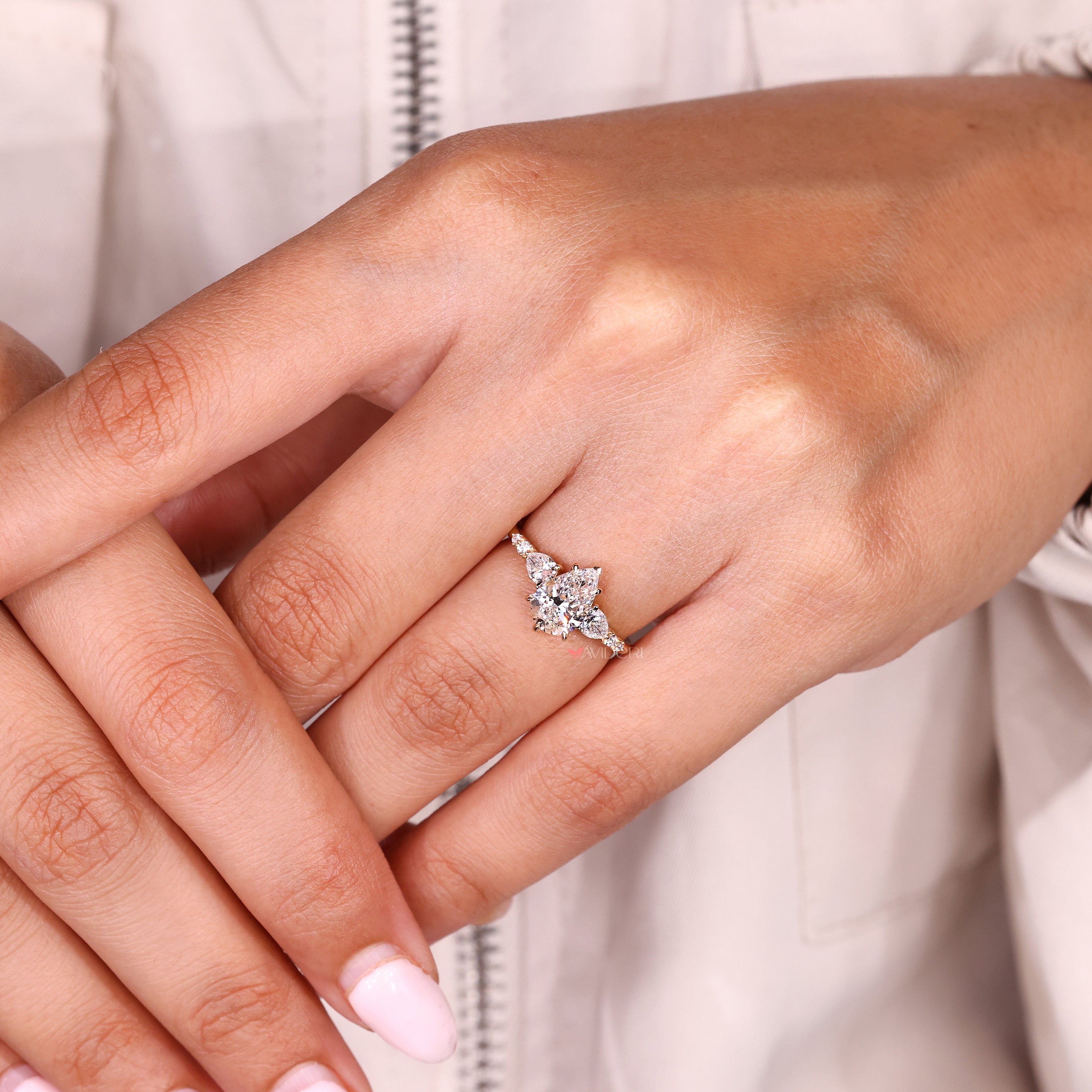 Pear diamond ring with basket setting and side stones
