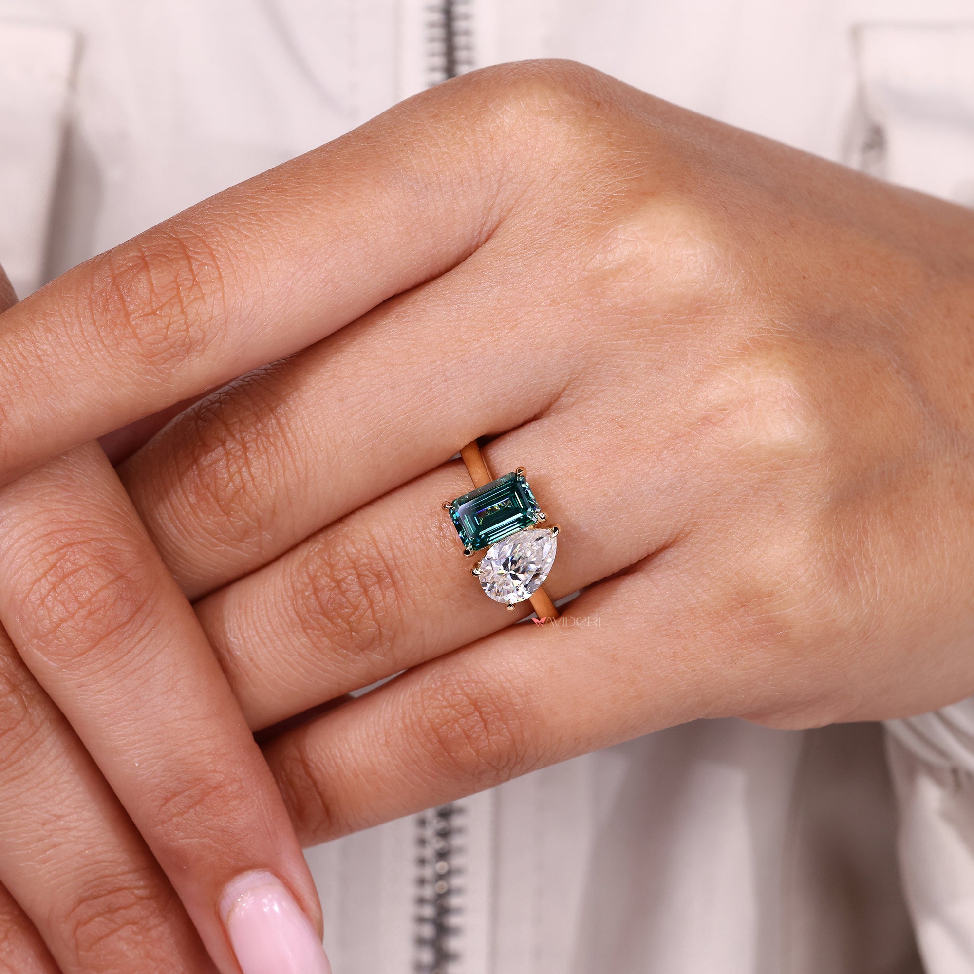 Emerald cut ring paired with pear stone in two stone engagement ring.